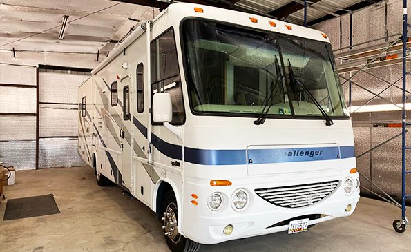 White RV parked in the garage, left angle